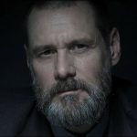 Portrait sombre de Jim Carrey en Tadek, un policier barbu au regard fatigué, plongé dans une atmosphère froide et oppressante.