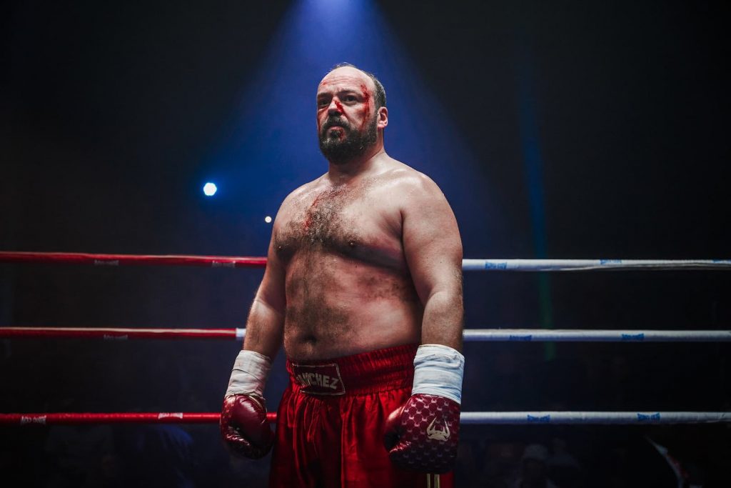 Portrait d'Alban Ivanov en boxeur ensanglanté, incarnant Luka Sanchez sur un ring de boxe dans le film Challenger.