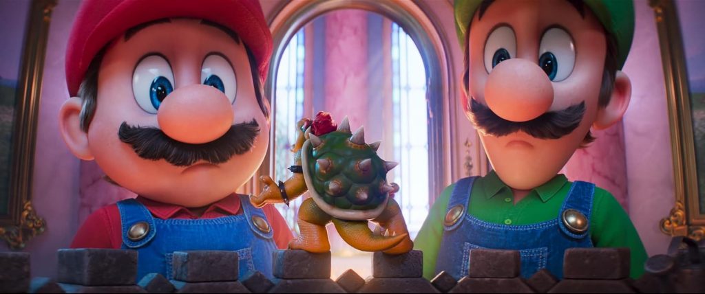 Image tirée du film d'animation Super Mario Galaxy, montrant Mario et Luigi, les deux personnages principaux avec leurs moustaches et leurs casquettes respectives (rouge et verte). Ils regardent vers le bas un petit Bowser avec sa carapace à épines verte. La scène se déroule dans une pièce élégante avec des ornements architecturaux et un grand miroir doré visible à l'arrière-plan.