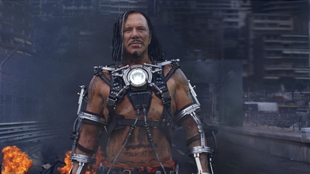 Mickey Rourke dans le rôle d'Ivan Vanko portant un exosquelette avec un réacteur arc lumineux sur le circuit de Monaco en flammes dans Iron Man 2.
